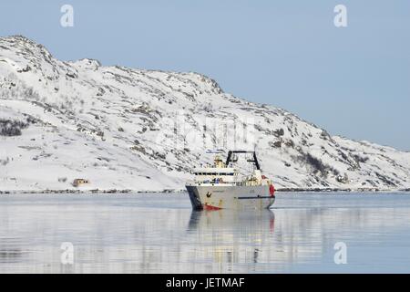 Weiß grau Fischereifahrzeug vor grauen weißen Hügeln auf das klare Wasser des Fjords in der Nähe von Kirkenes, 8. März 2017 | weltweite Nutzung Stockfoto