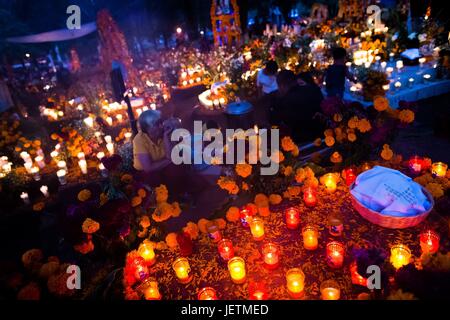 Mexikanische Familienmitglieder Kerzen und beten auf dem Friedhof zu Ehren ihrer verstorbenen Angehörigen während des Tages der toten Feier in Tzintzuntzan, Michoacan, Mexiko, 2. November 2014. Tag der Toten ('ÄòDia de Muertos' AO) ist eine synkretistische Mehrzahl | weltweite Nutzung Stockfoto