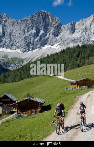 Mann und Frau mit Lenkrad in alpiner Landschaft, Mann Und Frau Mit Dem Rennrad in alpiner Landschaft Stockfoto