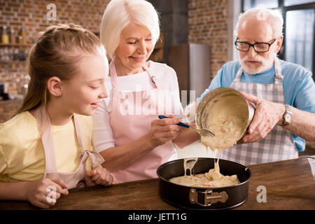 glückliche Großeltern und Mädchen gemeinsam kochen zu Hause Stockfoto