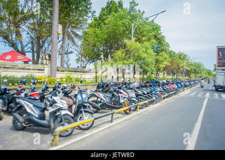 BALI - INDONESIEN MÄRZ 08. 2017: ein unbekannter Mann kümmert sich um Motorradfahrer in Dowtown geparkt. Legian Bereich. Legian ist eine s-Bahn und Strand Stockfoto