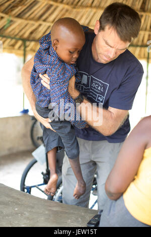 Ein Expat-Physiotherapeut hilft ein Junge mit Klumpfüße in Bundibugyo, Uganda. Stockfoto