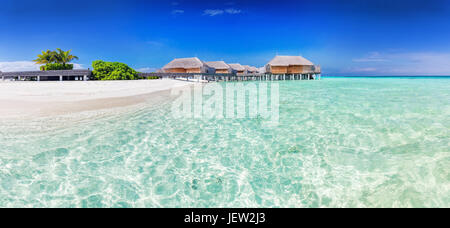 Panorama der breite Sandstrand auf einer tropischen Insel auf den Malediven. Wasservillen am Indischen Ozean. Stockfoto