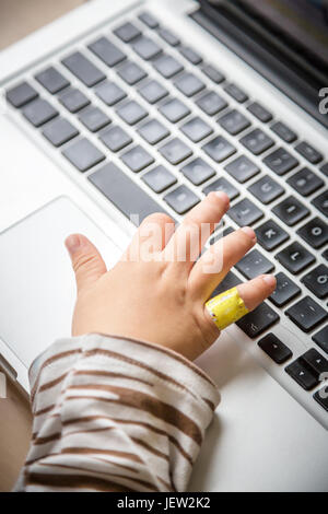 Childs hand aufs Laptop-Tastatur Stockfoto
