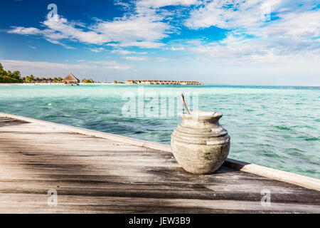 Holzsteg in Richtung einer kleinen Insel im Indischen Ozean, Malediven. Sonnigen blauen Himmel. Stockfoto