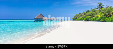 Panorama der breite Sandstrand auf einer tropischen Insel auf den Malediven. Kokospalmen und Wasser lodge am Indischen Ozean. Stockfoto