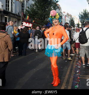 Brighton, ENGLAND - Menschen 11. August 2016 genießen das Brighton Gay Pride Festival. Transvestit in einem orangefarbenen T-shirt und Jeans Rock posiert in einer cro Stockfoto