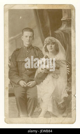 Original WW1 Ära verblasste Sepia Postkarte Studio Porträt von attraktiven Brautpaar, Soldat Mann in Armee Uniform, Frau trägt schönen Schleier und Kopfschmuck, trägt einen Strauß, um 1918, England, Großbritannien Stockfoto