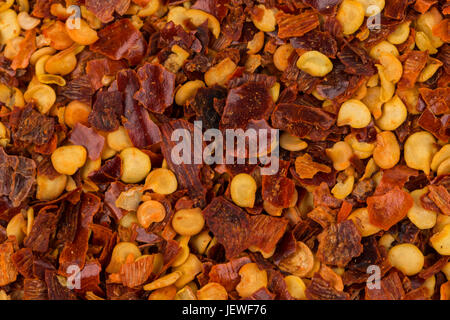 Der Haufen von zerkleinerten Paprika, getrocknete Chili-Flocken und Samen als Hintergrund Stockfoto