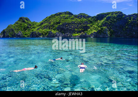 Touristen, die Schwimmen im kristallklaren Wasser im Bacuit Archipel, Palawan, Philippinen Stockfoto