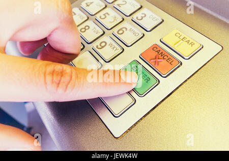 Frau Finger drücken Sie die Eingabetaste auf ATM close-up. Stockfoto