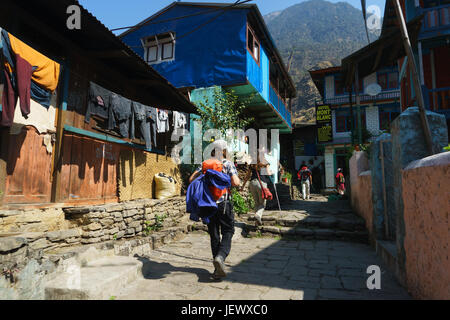 Trekker geht durch das Dorf jagat, auf der Annapurna Umrundung in Nepal. Stockfoto