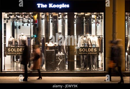 Blick auf Menschen, die nachts in verschwommene Bewegung vor Mode Marke im Le Marais Bezirk von Paris. Verkauf-Saison und Konsum-Konzept. Stockfoto