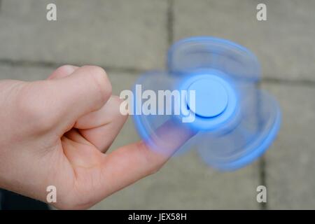 Osterode, Deutschland. 27. Juni 2017. Ein Junge spielt mit der derzeit populären, angeblich Entspannungsglühen Spielzeug bekannt als ein "Fidget Spinner", Deutschland, Stadt Osterode, 27. Juni 2017. Foto: Frank Mai (Modell freigegeben) | weltweite Nutzung/Dpa/Alamy Live-Nachrichten Stockfoto