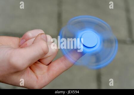 Osterode, Deutschland. 27. Juni 2017. Ein Junge spielt mit der derzeit populären, angeblich Entspannungsglühen Spielzeug bekannt als ein "Fidget Spinner", Deutschland, Stadt Osterode, 27. Juni 2017. Foto: Frank Mai (Modell freigegeben) | weltweite Nutzung/Dpa/Alamy Live-Nachrichten Stockfoto