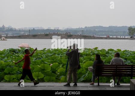 (170628)--HANGZHOU, 28. Juni 2017 (Xinhua)--Menschen genießen Sie die Landschaft von Lotusblüten in West Lake Hangzhou, Hauptstadt der ostchinesischen Provinz Zhejiang, 28. Juni 2017. Lotusblumen hier trat ihre beste Zeit des Jahres, und die Blütezeit dauert bis Anfang September. (Xinhua/Huang Zongzhi) (Wjq) Stockfoto