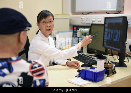 (170628)--SHENZHEN, 28. Juni 2017 (Xinhua)--Lee Wing Mui Anne zeigt ein Patient seine medizinische Bericht am Queen Mary Hospital in Hongkong, Südchina, 22. Juni 2017. Lee, ein Arzt aus China Hong Kong, ist auch der Leiter des Zentrums für klinische Onkologie am Klinikum der Universität Hongkong und Shenzhen. Eingeladen von der University of Hong Kong, begann Lee ihre Arbeit im Krankenhaus im Oktober 2012. In den vergangenen fünf Jahren reiste sie von Hong Kong nach Shenzhen zwei Tage pro Woche, die medizinischen Dienstleistungen und die Teilnahme an Management-Arbeit zur Verbesserung der Zusammenarbeit und Kommunikation zwischen Stockfoto