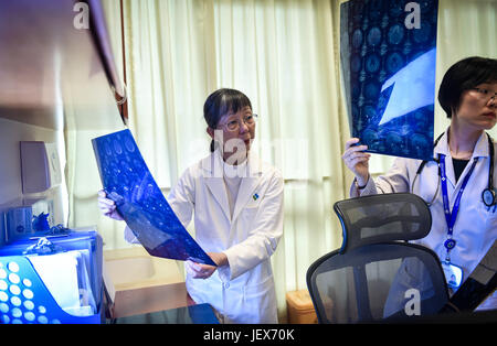 (170628)--SHENZHEN, 28. Juni 2017 (Xinhua)--Lee Wing Mui Anne (L) prüft ein Patient CT Bericht an der University of Hong Kong-Shenzhen Krankenhaus in Shenzhen, Südchina, 21. Juni 2017. Lee, ein Arzt aus China Hong Kong, ist derzeit der Leiter des Zentrums für klinische Onkologie am Klinikum. Eingeladen von der University of Hong Kong, begann Lee ihre Arbeit im Krankenhaus im Oktober 2012. In den vergangenen fünf Jahren reiste sie von Hong Kong nach Shenzhen zwei Tage pro Woche, medizinische Dienstleistungen und die Teilnahme an Management-Arbeit zur Verbesserung der Zusammenarbeit und Kommunikation zwischen Brooch Stockfoto