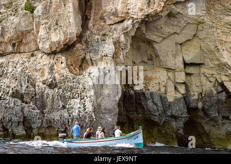 27. September 2004 - Zurrieq Dorf, Malta - Touristen und ihre lokalen Führer in einem bunten traditionellen maltesischen Fischerboot genannt ein Luzzu Höhlen Tour die Blaue Grotte, eine wilde Bildung von natürlichen Felsen und Meer vor der südlichen Küste von Malta, ein beliebtes internationales Touristenziel. (Kredit-Bild: © Arnold Drapkin über ZUMA Draht) Stockfoto