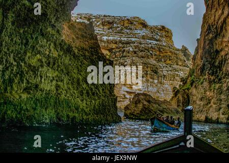 27. September 2004 - Zurrieq Dorf, Malta - Touristen und ihre lokalen Führer in einem bunten traditionellen maltesischen Fischerboot genannt ein Luzzu Höhlen Tour die Blaue Grotte, eine wilde Bildung von natürlichen Felsen und Meer vor der südlichen Küste von Malta, ein beliebtes internationales Touristenziel. (Kredit-Bild: © Arnold Drapkin über ZUMA Draht) Stockfoto