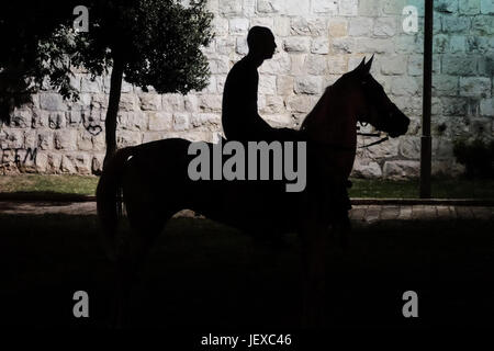 Jerusalem, Israel. 28. Juni 2017. Ein junger arabischer Mann reitet auf einem Pferd in der Nähe der alten Stadtmauern. Bildnachweis: Nir Alon/Alamy Live-Nachrichten Stockfoto