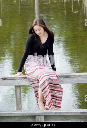 Mädchen auf einer Bank am Wasser Stockfoto