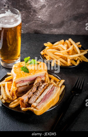 Traditionelle portugiesische snack Essen. Francesinha Sandwich-Brot, Käse, Schweinefleisch, Schinken, Wurst, Tomaten-Bier-Sauce und Pommes Frites. Mit einem Glas-o Stockfoto