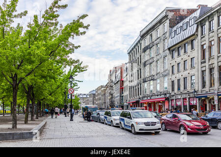 Montreal, Kanada - 27. Mai 2017: Altstadt mit Restaurants, Polizeiautos auf Straße und Passanten in Stadt in der Region Quebec während des Sonnenuntergangs Stockfoto