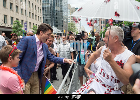 Toronto, Kanada. 25. Juni 2017. Der kanadische Premierminister Justin Trudeau grüßt Fan Jamie Godin und schaut auf seine "Zweitname-Outfit. Stockfoto