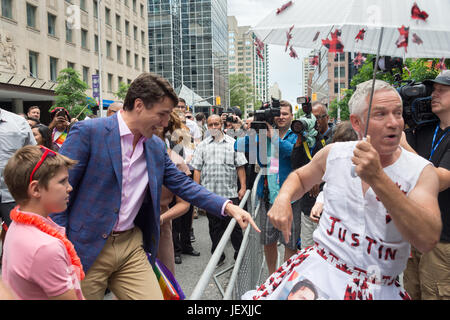 Toronto, Kanada. 25. Juni 2017. Der kanadische Premierminister Justin Trudeau grüßt Fan Jamie Godin und schaut auf seine "Zweitname-Outfit. Stockfoto