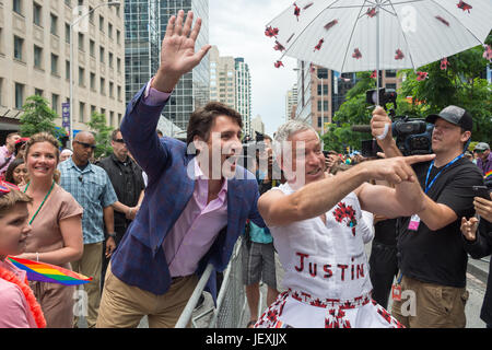 Toronto, Kanada. 25. Juni 2017. Kanadische Premierminister Justin Trudeau mit Ventilator Jamie Godin, die aus einem "Zweitname Outfit während Gay Parade. Stockfoto