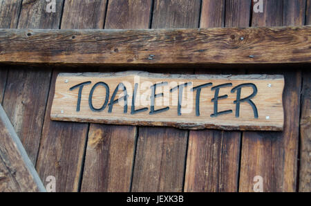 Alte Holztür mit Schild in Schwedisch, die Toiletten zu sagen Stockfoto