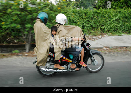 Familie pendeln auf kleine Motorrad mit kleinen Kind ohne Helm Stockfoto