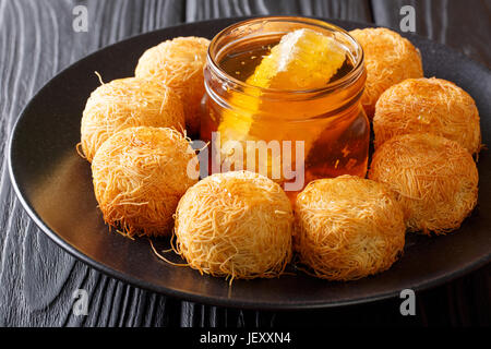 Türkische Süßigkeiten Kugeln der Künefe mit Honig Nahaufnahme auf einer Platte. horizontale Stockfoto