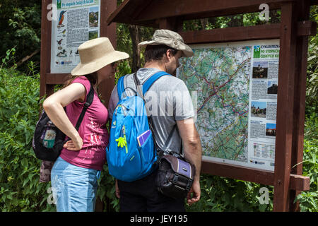 Menschen mittleren Alters Wandern, ein Paar auf einer Reise in das Tal des Flusses Berounka, Blick auf Informationstafel mit einer Karte Tschechische Republik Wandern Europa Stockfoto