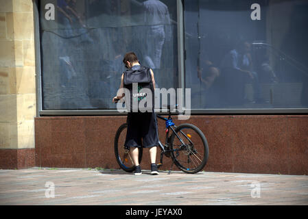junger Mann Junge Lieferung Fahrrad Radfahrer Uber Essen Lieferung Fahrrad wartet auf Arbeit Stockfoto