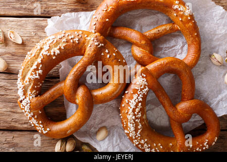 Frisch gebackene weiche Brezel mit großzügigen Prise grobes Salz close-up auf dem Tisch. horizontale Ansicht von oben Stockfoto