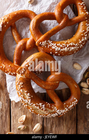 Frisch gebackene weiche Brezel mit großzügigen Prise grobes Salz close-up auf dem Tisch. vertikale Ansicht von oben Stockfoto