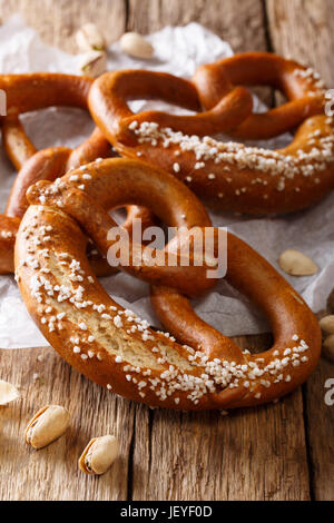 Frisch gebackene traditionellen Brezel mit Salz Nahaufnahme auf dem Tisch. Vertikal Stockfoto