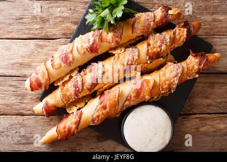 Grissini mit Speck und Käse Nahaufnahme "und" Knoblauch-Sauce auf den Tisch. horizontale Ansicht von oben Stockfoto