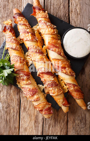 Grissini mit Speck und Käse Nahaufnahme "und" Knoblauch-Sauce auf den Tisch. vertikale Ansicht von oben Stockfoto