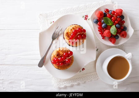 Kokos-Muffins mit Beeren und Kaffee mit Milch Nahaufnahme auf dem Tisch. horizontale Ansicht von oben Stockfoto