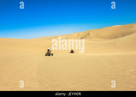 Quad fahren - zwei glückliche Biker im Sand der Wüste. Stockfoto