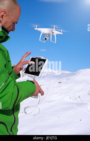 Mannhände Umgang mit Drohne in Winterpanorama Berglandschaft Stockfoto