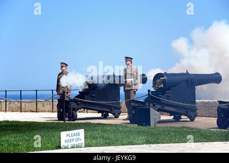 Soldaten schießen Kanonen für die Mittagszeit Waffe in Upper Barrakka Gardens, Valletta, Malta, Europa. Stockfoto