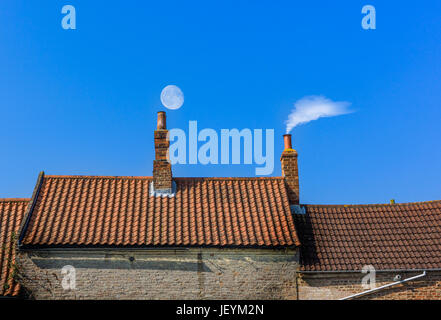 Schornstein-Dachlinie mit Mond und Rauch Stockfoto