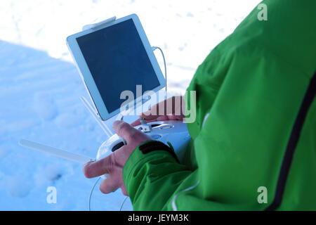 Mannhände Umgang mit Drohne in Winterpanorama Berglandschaft Stockfoto