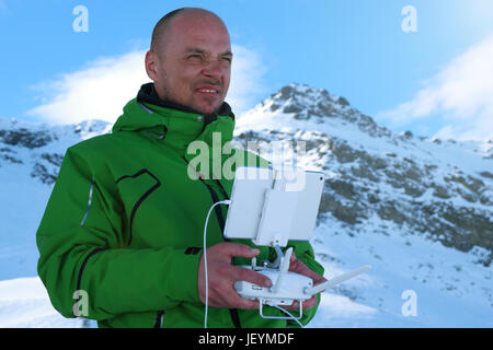 Mannhände Umgang mit Drohne in Winterpanorama Berglandschaft Stockfoto