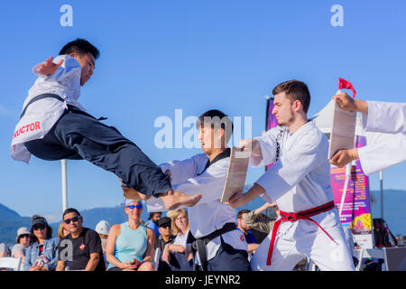 Tae Kwon Do Gruppe High Kick und brechen Holzplanken in Kanada 150 Multi-Cultural Tag Ereignis, Vancouver, British Columbia, Kanada. Stockfoto