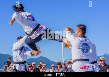 Tae Kwon Do Gruppe High Kick und brechen Holzplanken in Kanada 150 Multi-Cultural Tag Ereignis, Vancouver, British Columbia, Kanada. Stockfoto